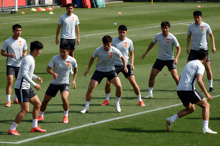 足球队在训练场上进行战术跑位训练的场面